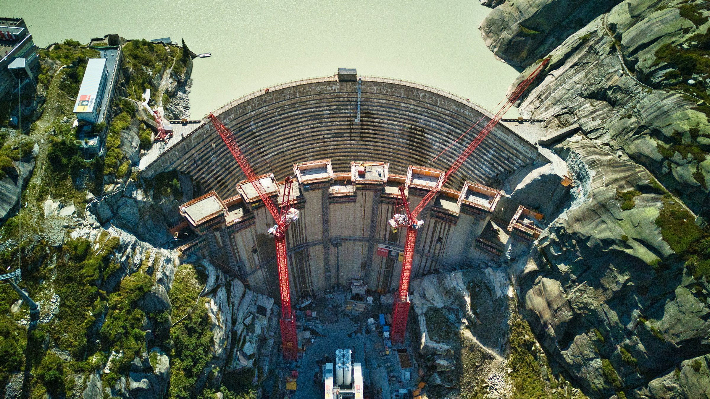 Aerial view of a large construction project integrated into mountain terrain