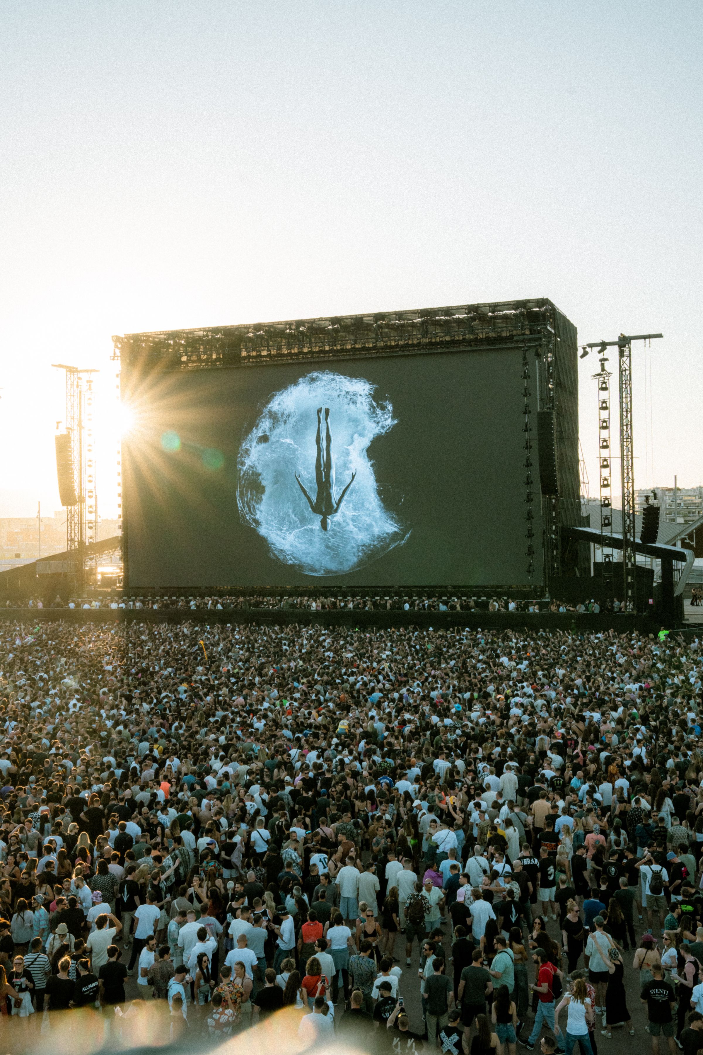 Large festival audience filling the space in front of a stage