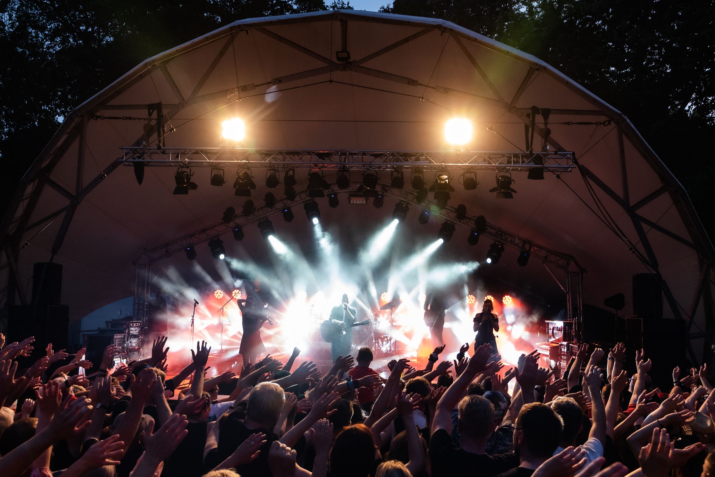 A real outdoor concert audience facing a live performance stage